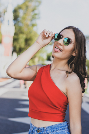 modelo joven con gafas sacando la lengua